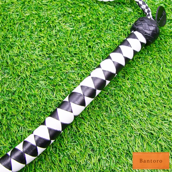 bdsm dragon tail whip black white braided handle close up