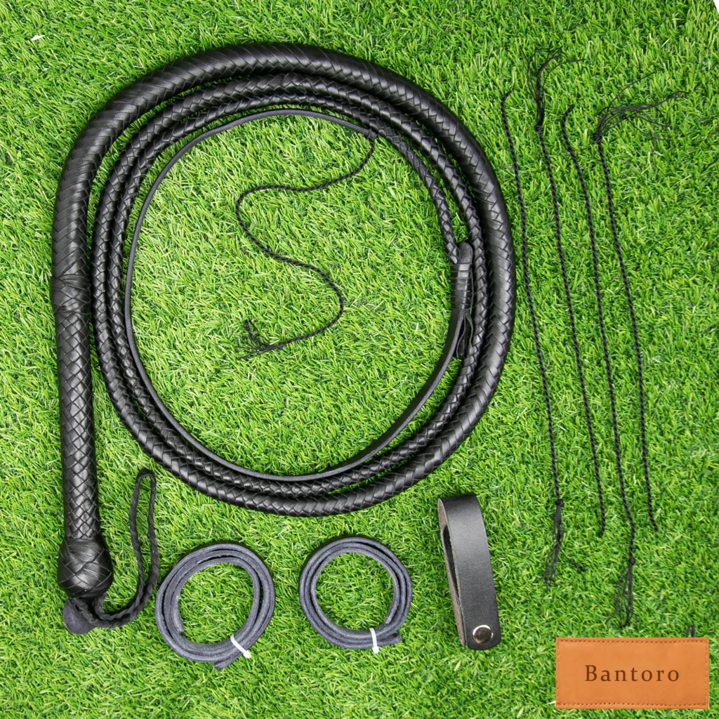Handcrafted premium leather bullwhip placed on green grass background