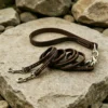 Double dog leash coiled in brown full-grain leather with reinforced stitching and brass hardware